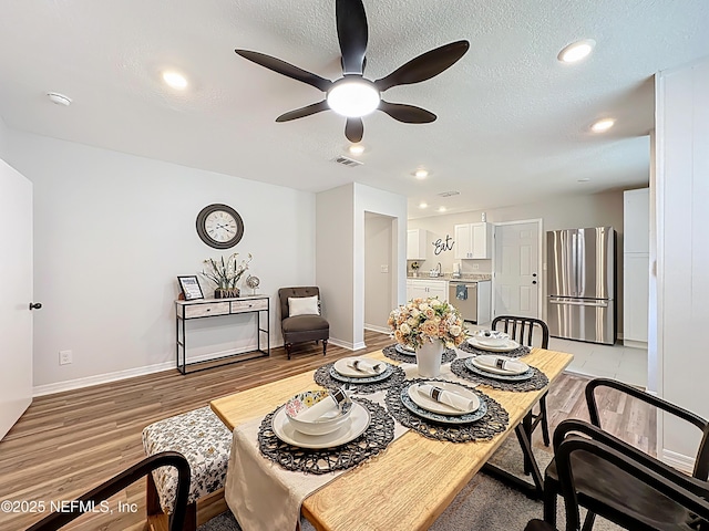 dining area featuring light wood finished floors, a ceiling fan, visible vents, and recessed lighting
