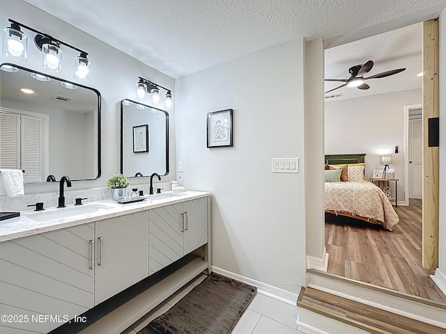 full bath featuring a textured ceiling, visible vents, ensuite bath, and a sink