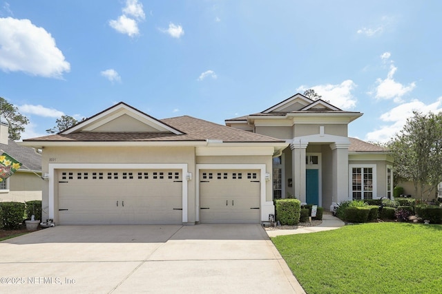1695 Waters Edge Dr, Fleming Island, FL 32003 - view of front of house featuring concrete driveway, a garage, a front yard, and stucco siding