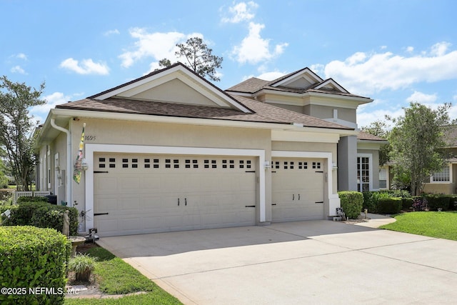 1695 Waters Edge Dr, Fleming Island, FL 32003 - view of front of home with a shingled roof, stucco siding, an attached garage, and driveway