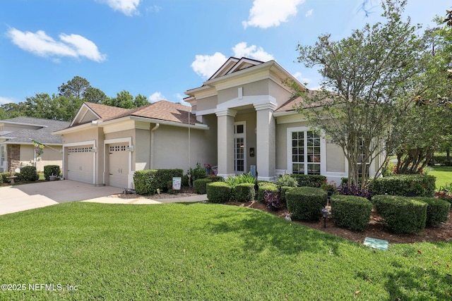 1695 Waters Edge Dr, Fleming Island, FL 32003 - view of front of house with a shingled roof, a front lawn, a garage, stucco siding, and concrete driveway