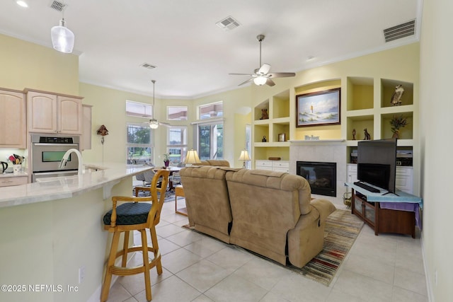 1695 Waters Edge Dr, Fleming Island, FL 32003 - living area with a ceiling fan, visible vents, ornamental molding, and light tile patterned flooring