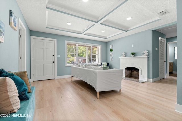 bedroom featuring coffered ceiling, light wood-style flooring, a fireplace, baseboards, and a textured ceiling