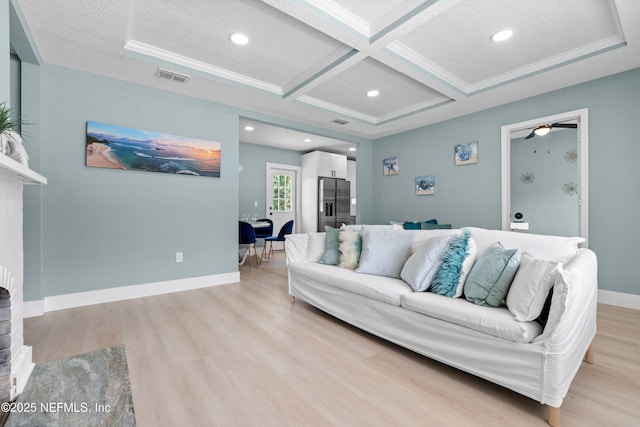 living room with visible vents, light wood-type flooring, coffered ceiling, and baseboards