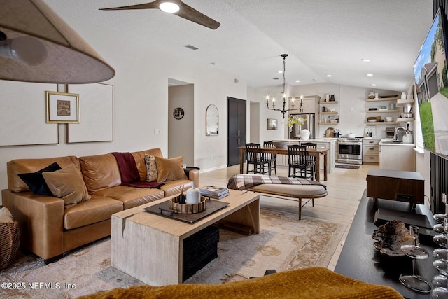 living room featuring visible vents, ceiling fan with notable chandelier, and lofted ceiling