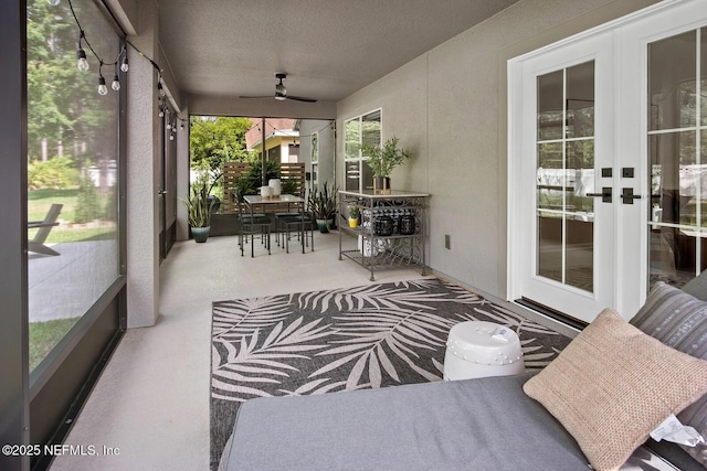 sunroom / solarium with a ceiling fan and french doors