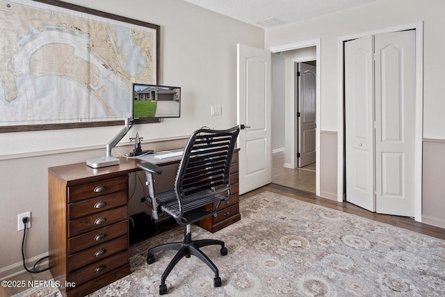 home office featuring baseboards and wood finished floors