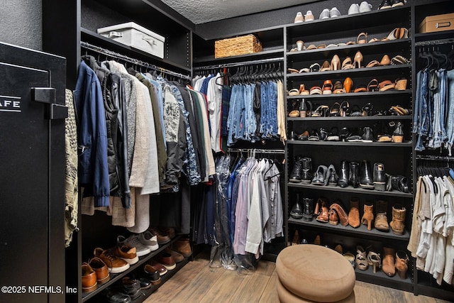 walk in closet with wood finished floors