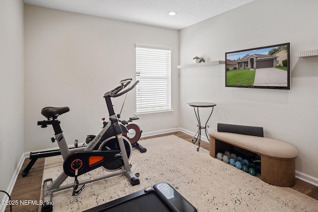 workout room with baseboards and wood finished floors