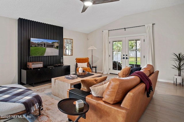 living area with french doors, a ceiling fan, baseboards, lofted ceiling, and light wood-type flooring