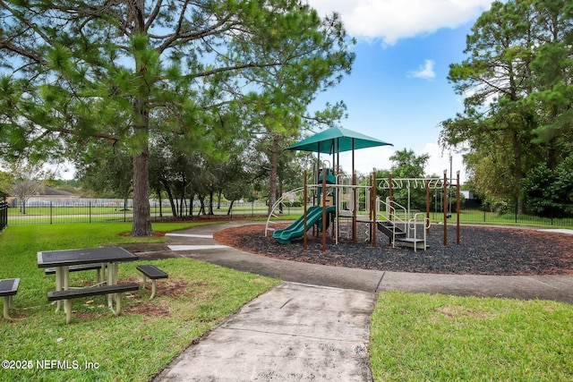 communal playground with a yard and fence