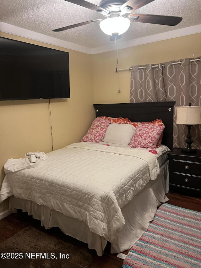 bedroom featuring a textured ceiling, wood finished floors, and ceiling fan