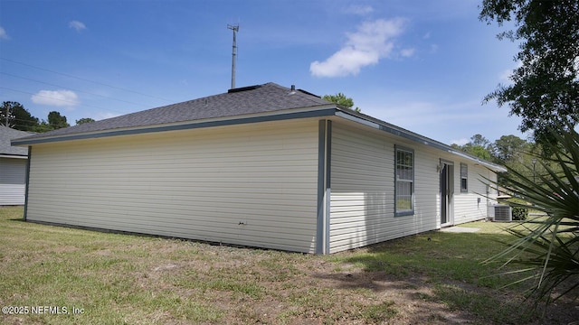 view of home's exterior featuring a lawn, roof with shingles, and central AC unit