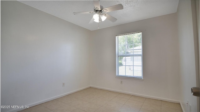 empty room featuring light tile patterned floors, a textured ceiling, ceiling fan, and baseboards