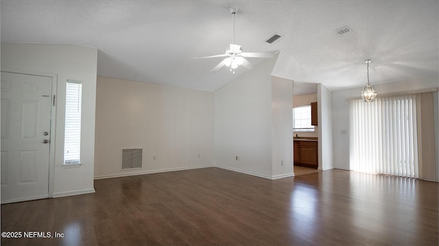 unfurnished living room featuring visible vents, ceiling fan, and vaulted ceiling