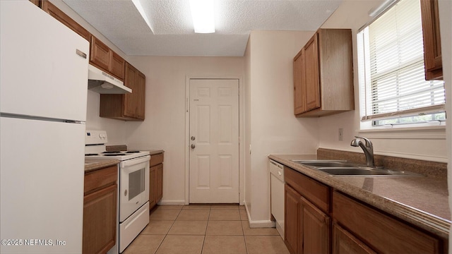kitchen featuring a sink, under cabinet range hood, light tile patterned floors, white appliances, and a textured ceiling