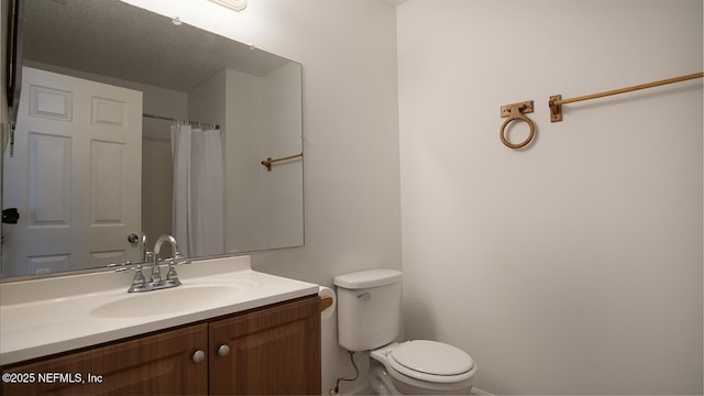 bathroom with vanity, toilet, and baseboards