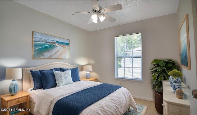 8878 Scott Woods Dr W, Jacksonville, FL 32208 - bedroom featuring light tile patterned floors, baseboards, a ceiling fan, and a textured ceiling
