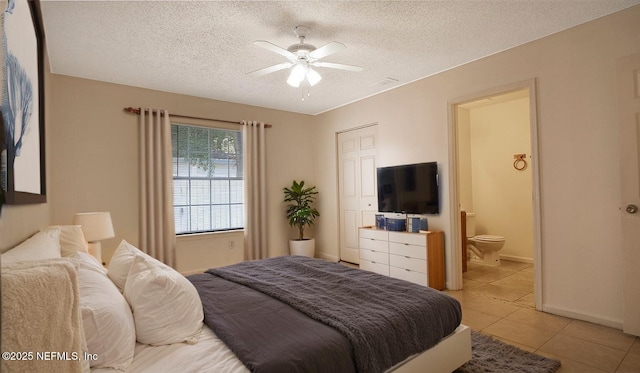 8878 Scott Woods Dr W, Jacksonville, FL 32208 - bedroom featuring a textured ceiling, light tile patterned flooring, ensuite bath, visible vents, and baseboards