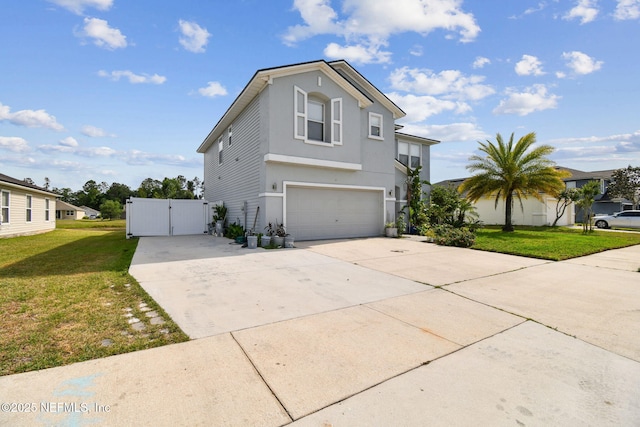 view of front of home with a gate, a garage, a front lawn, and driveway
