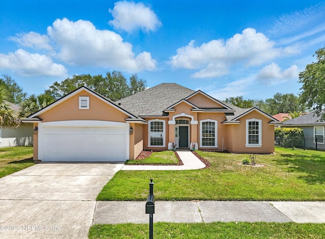 view of front facade with a front lawn, stucco siding, driveway, an attached garage, and fence