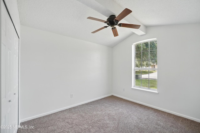 carpeted spare room featuring baseboards, a wealth of natural light, a textured ceiling, and ceiling fan