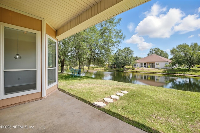 view of yard with a water view and a patio