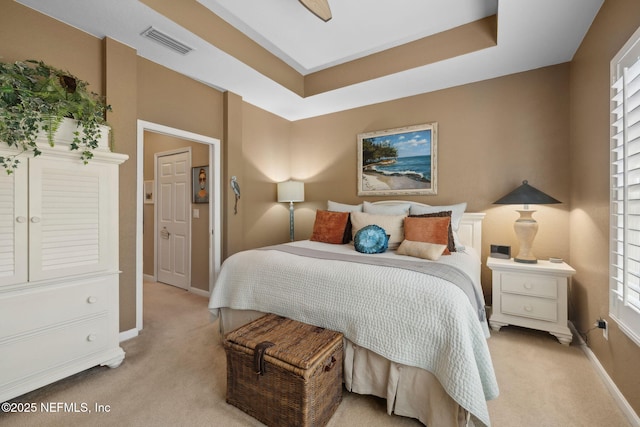 bedroom with visible vents, baseboards, and light carpet