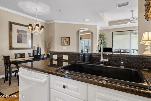 kitchen with arched walkways, ornamental molding, dishwasher, and a sink