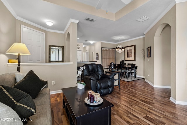 living room with baseboards, wood finished floors, and arched walkways