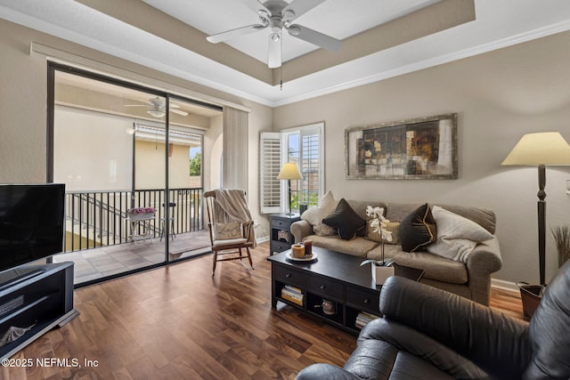 living room with ornamental molding, ceiling fan, wood finished floors, and baseboards