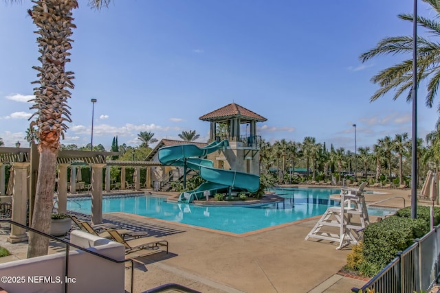 pool with a water slide and a patio area