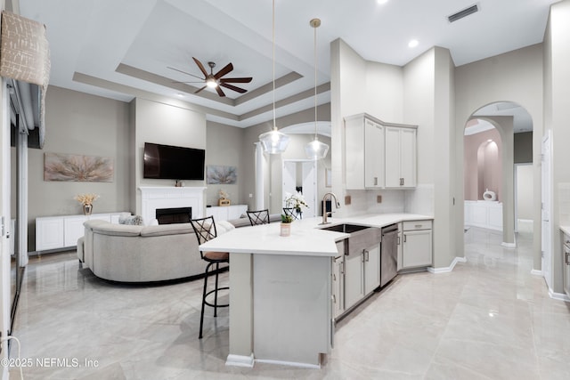 1071 Green Pine Cir, Orange Park, FL 32065 - kitchen featuring light marble finish flooring, ceiling fan, arched walkways, a breakfast bar, and a high ceiling
