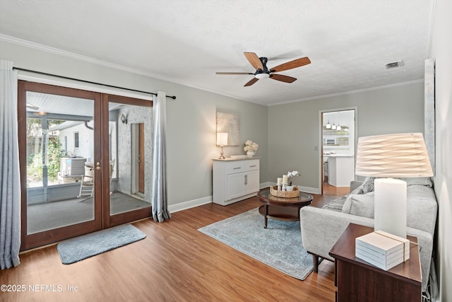 living room with wood finished floors, baseboards, visible vents, a ceiling fan, and french doors
