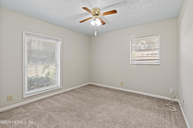 carpeted empty room with a ceiling fan, a textured ceiling, and baseboards