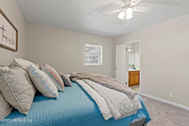 bedroom with a textured ceiling, baseboards, light carpet, a ceiling fan, and ensuite bath