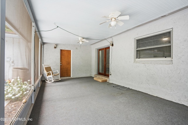 unfurnished sunroom featuring ceiling fan and french doors