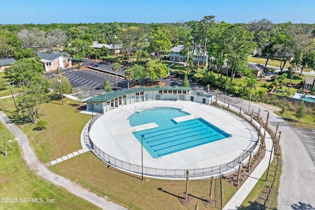 view of pool with fence and a lawn
