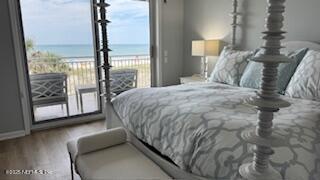 1415 1st St N Unit 302, Jacksonville Beach, FL 32250 - bedroom with multiple windows, wood finished floors, baseboards, and view of water and beach