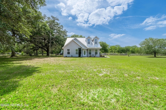 view of front of property with metal roof and a front lawn