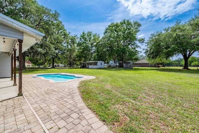 outdoor pool with a patio and a lawn