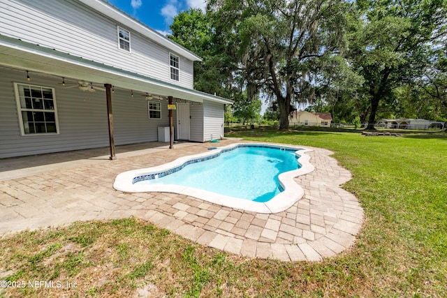 outdoor pool featuring a patio, a ceiling fan, and a yard