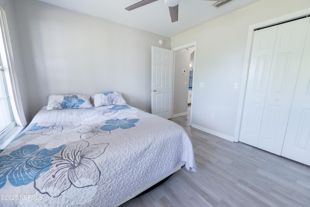 bedroom featuring wood finished floors, ceiling fan, baseboards, and a closet