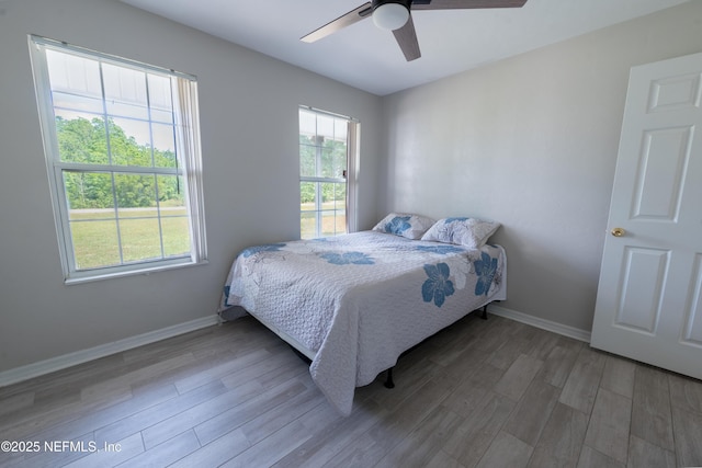 bedroom featuring wood finished floors, ceiling fan, and baseboards