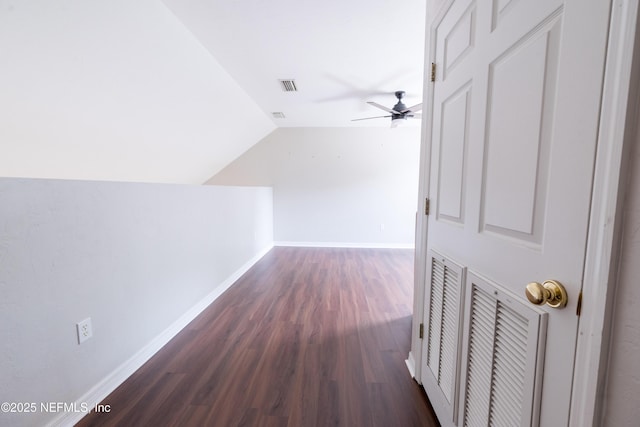additional living space featuring dark wood-style flooring, baseboards, visible vents, a ceiling fan, and lofted ceiling