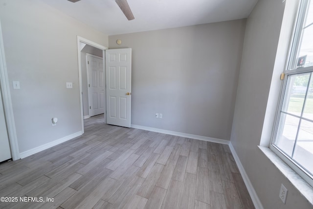 empty room with ceiling fan, baseboards, and light wood-style floors