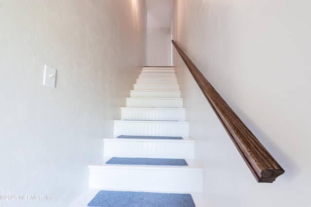 stairs featuring a textured wall