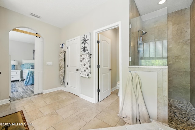 bathroom with visible vents, walk in shower, baseboards, toilet, and ensuite bath