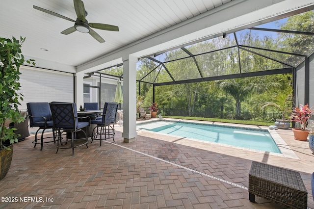 pool with a ceiling fan, a patio area, glass enclosure, a fenced backyard, and outdoor dining space