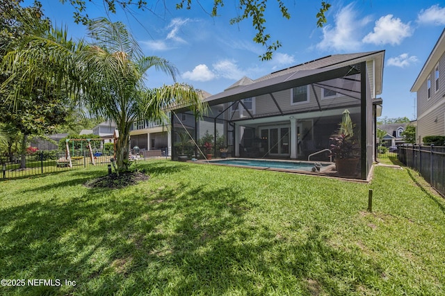 back of property featuring a lawn, a fenced in pool, a fenced backyard, and glass enclosure